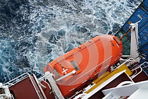 Orange colour life boat with reflective tape stickers observed from top