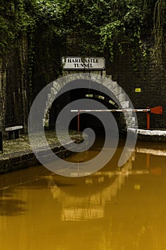 Orange coloured canal with northern entrance to the Harecastle Tunnel, The Trent and Mersey Canal