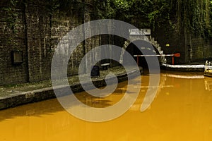 Orange coloured canal with northern entrance to the Harecastle Tunnel, The Trent and Mersey Canal