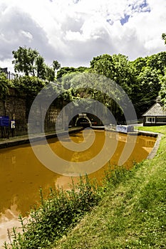 Orange coloured canal with northern entrance to the Harecastle Tunnel, The Trent and Mersey Canal