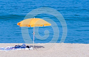 Orange coloured parasol umbrella on the beach in the summer holiday