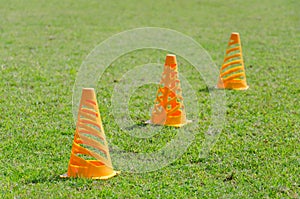 Orange cone markers on the green grass