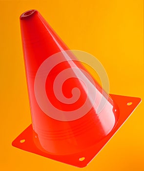 Orange cone, road barrier isolated on a yellow background