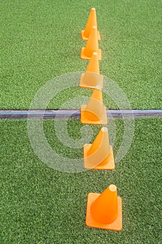 Orange cones on green artificial grass