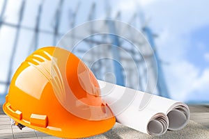 Orange construction helmet with blueprint, engineer safety.