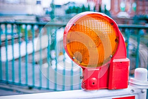 Orange construction warning street barrier light on barricade. Road construction on the streets of European cities