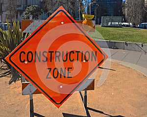 Orange construction zone sign on barricade