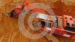 Orange crawler excavator standing on sand mine. Mining excavator