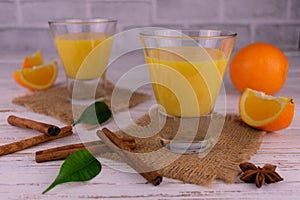 Orange cream mousse and juicy oranges with cinnamon on a light background