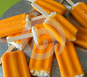 Orange creamsicle popsicles on a galvanized steel platter.