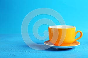 Orange cup on blue wooden background