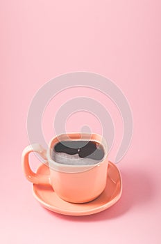 orange cup of espresso on a pink background/orange cup of espresso with a foam on a pink background with copy space