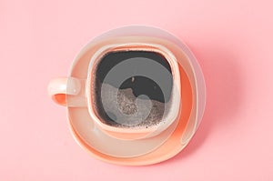 orange cup of espresso on a pink background/orange cup of espresso with a foam on a pink background, top view