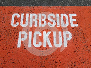 orange curbside pickup sign on asphalt or ground