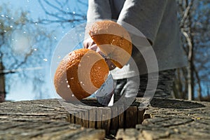 an orange is cut in the air with a knife.