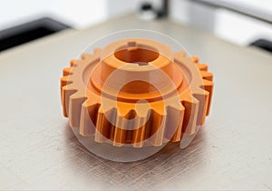 Of orange 3d printed gear on, showcasing manufacturing