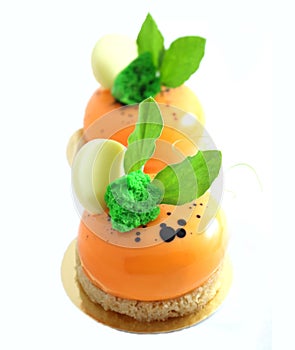 Orange desserts with green leaves and white chocolate photo