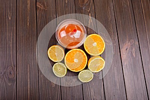 orange detox coctail with half orange,lemon and lime lies on tab