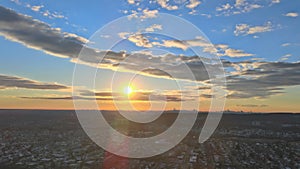 Orange dramatic sky with clouds for beautiful sunrise in a above aerial view New York City of a small town in