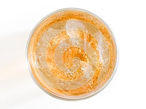 Orange drink with ice top view.