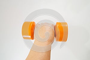 Orange dumbbell in a female hand on a white background.