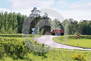 Orange Dump Truck moves on road on hill in green grass