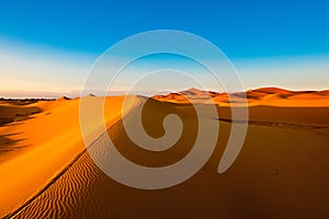 Orange dune ridge with riffles in the desert of Sahara, Morocco