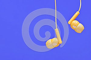 Orange earbuds on a plain blue background.