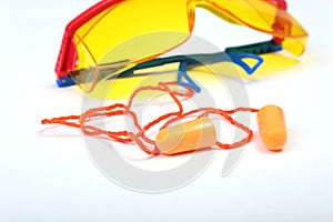 Orange earplug and safety glasses for work. Earplug to reduce noise on a white background .
