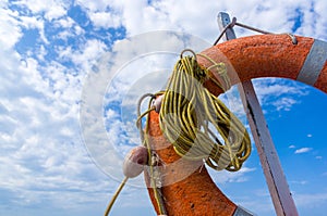 Orange emergency lifebuoy on a pebbly sea beach, close up