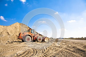 Orange excavator on a construction site photo