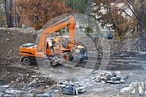 Orange excavator and wheel loader in a construction site