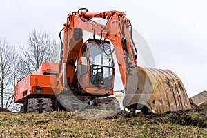 Orange excavator working on construction site