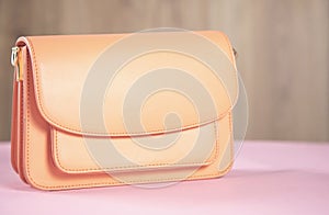 Orange fashion handbag on table