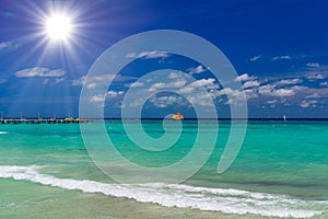 Orange ferry in azure ocean with swimming people in Playa del Carmen, Yukatan, Mexico