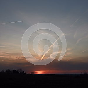 Orange FingerLakes sunset clouds with sun pillar and shadow photo