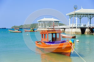 Orange fishing boat on a pebble beach