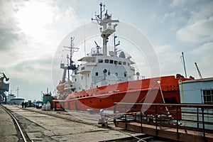 Orange fishing vessel docked at port. Angling boat ready for maritime journey. Industrial trawler for commercial fishery