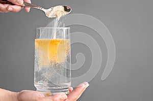 Orange fizzy powder and water glass with copy space. Healthy supplement