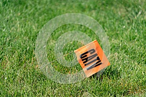 Orange flag with letters CATV on a grass background