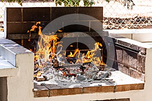 Orange flames and red hot coals in the fireplace outdoor