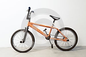 Orange flatland bicycle parking in office white Background