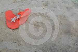 Orange flip flops on a beach