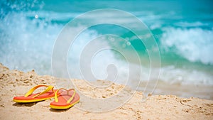 Orange flip flops or slippers on the beach