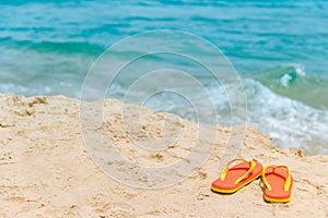 Orange flip flops or slippers on the beach