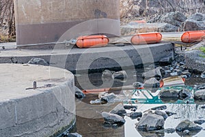 Orange floats on rocky river shore