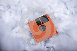 Orange floppy disk in the clouds