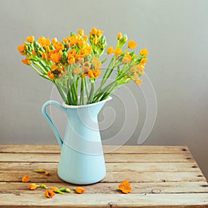 Orange flowers in blue jug