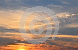 Orange fluffy sunset clouds over blue sky