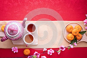 Orange fruit, Pink cherry blossom and teapot with Copy space for text on red texture background, Chinese new year background